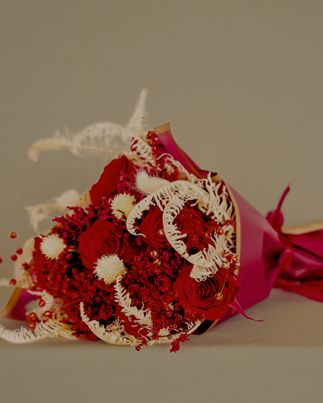 a classic dried red rose bouquet wrapped in red paper
